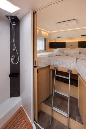 Nomad Camper interior in Albania featuring a sleek, compact design with a bedroom and integrated shower, maximizing space in a stylish mobile home