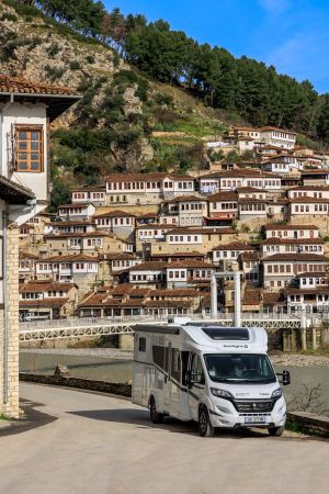 A Nomad Camper parked in front of the historic Ottoman-style architecture of Berat, Albania, blending modern travel with the charm of ancient traditions
